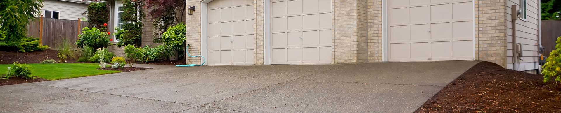 Beige House With Three Car Garage and Driveway