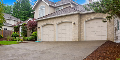 Beige House With Three Car Garage and Driveway