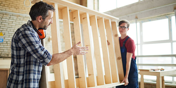 Two Men Carrying Wooden Bed Frame