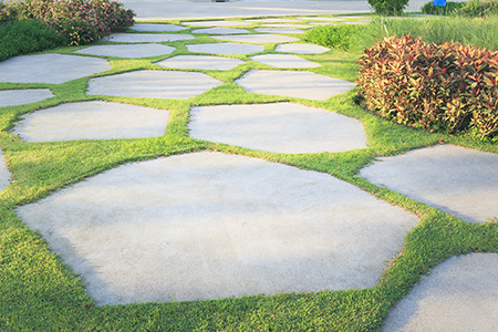 Concrete slabs being reused as pavers in a yard. 