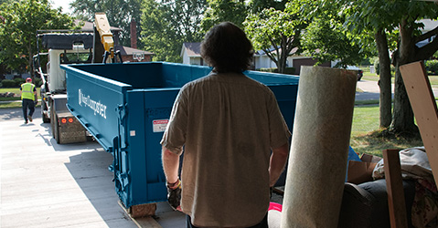Customer Watching Roll Off Dumpster Delivery