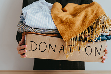 Box of Donations Containing Clothes and a Blanket