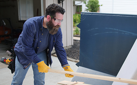 Contractor Filling Blue Dumpster