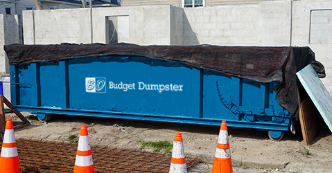 Blue Roll Off Dumpster Covered With Black Tarp