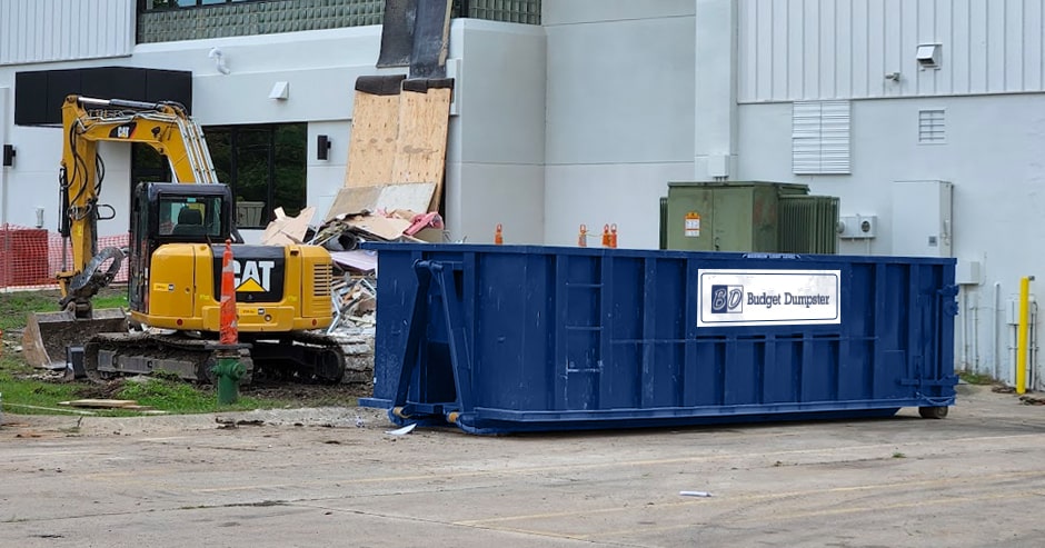 Man Carrying Household Debris Into a Dumpster