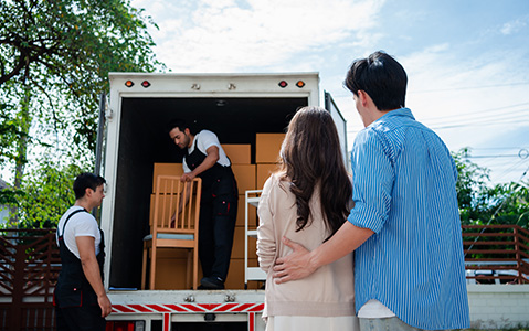 Couple Watching Junk Removal Company Haul Away Household Items