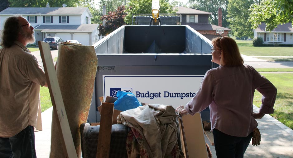 Couple in Front of Dumpster With a Pile of Junk