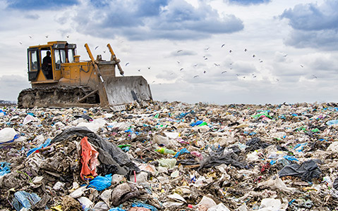 Landfill With Truck Driving on Top of Trash