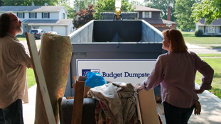 Couple Ready to Toss Household Debris Into a Dumpster
