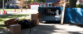 Roll Off Dumpster in a Driveway Being Loaded With Debris