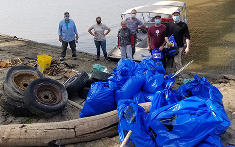 Volunteers at a waterway cleanup looking at the piles of trash collected.