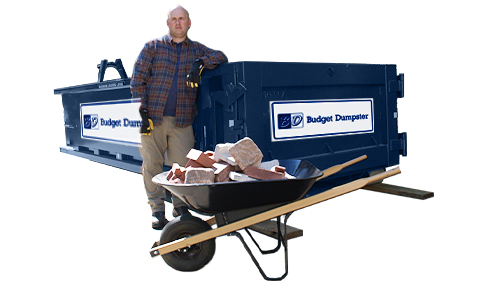 Man With a Wheelbarrow Full of Construction Materials in Front of a Roll Off Dumpster