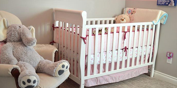 White Crib and Rocking Chair in Pink Bedroom